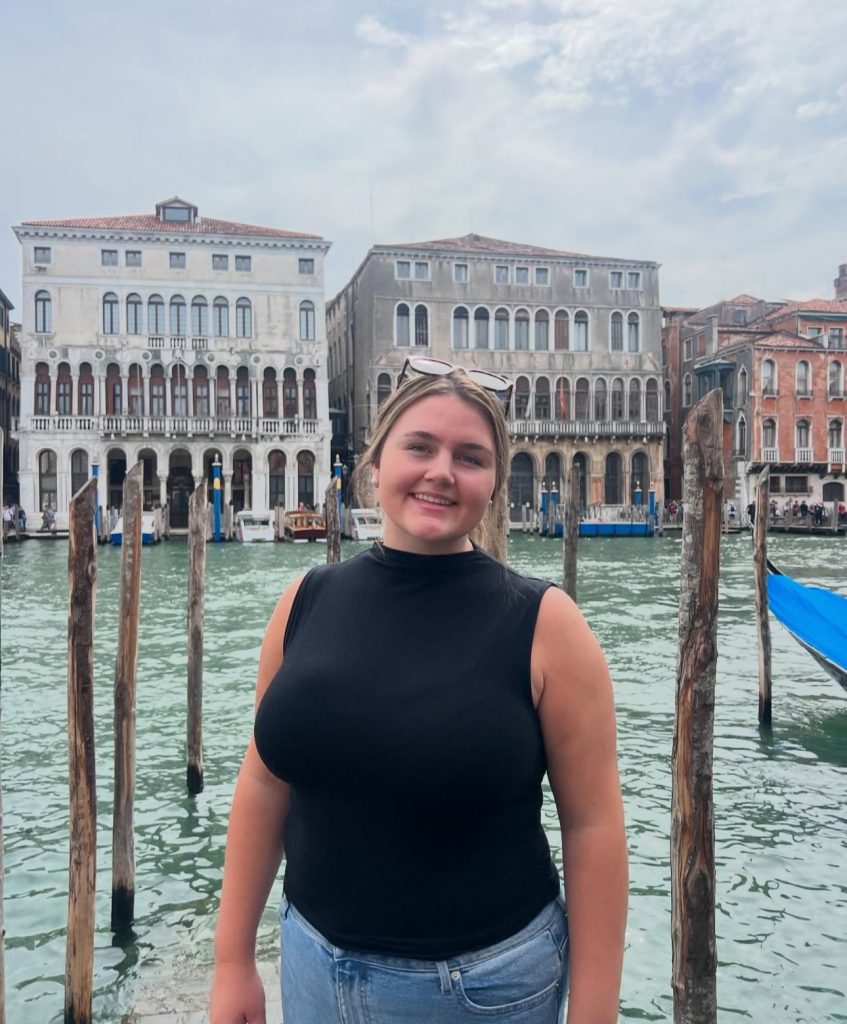 Image of Madison Dunstan in front of a body of water and buildings