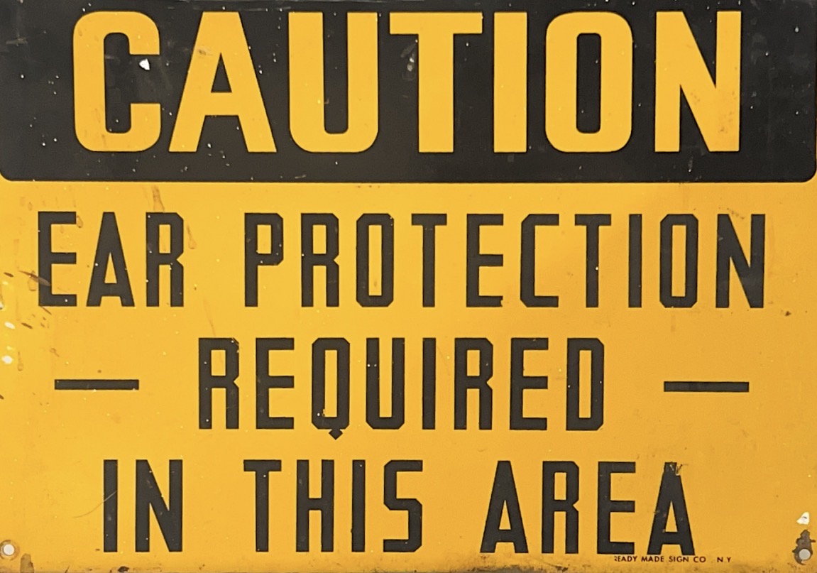 Yellow "caution, ear protection required in this area" sign
